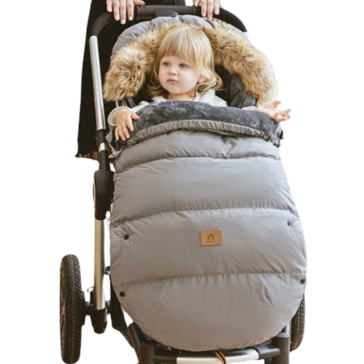 hanceliere grise en usage dans poussette, capuche pelucheuse entourant le visage d’une petite fille