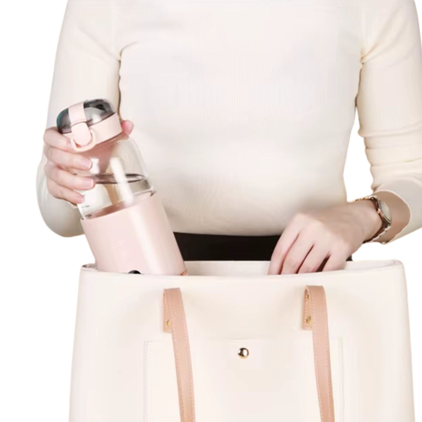 Chauffe biberon nomade rose glissé dans un sac à main blanc