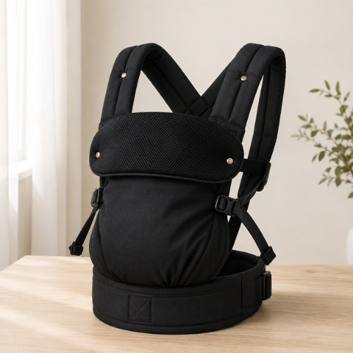 Porte bébé ventral et dorsal noir présenté seul sur une table, vue de face
