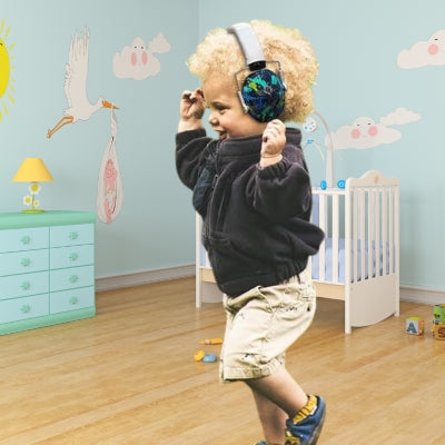 Enfant portant un casque anti-bruit bébé blanc ZenListen dans une chambre d’enfant, jouant librement tout en étant protégé du bruit