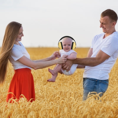 Casque anti bruit bébé jaune offrant une tranquillité parfaite, même dans un champ en plein air, avec CalmProtect