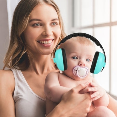 Casque antibruit bébé vert assurant un calme apaisant pendant un moment tendre avec sa maman, grâce à CalmProtect