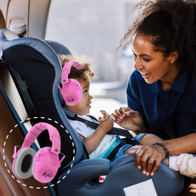 Bébé dans un siège auto, portant un casque antibruit enfant rose, assurant une réduction des bruits pour un voyage apaisé