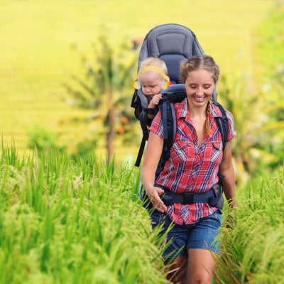 Maman et bébé en randonnée, avec le casque antibruit pour bébé jaune JauneCocon assurant confort et tranquillité pour l’enfant