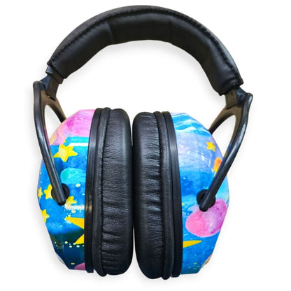 Casque antibruit enfant vu de face, bandeau rembourré et coques illustrées espace et étoiles