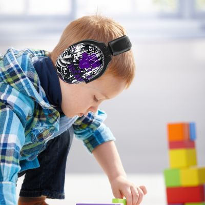 Petit garçon concentré sur des blocs éducatifs, portant un casque antibruit VioletEdge violet pour un environnement calme et propice à l’apprentissage