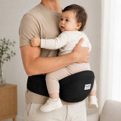 Porte bebe hip seat noir avec assise de hanche, enfant face au porteur en intérieur