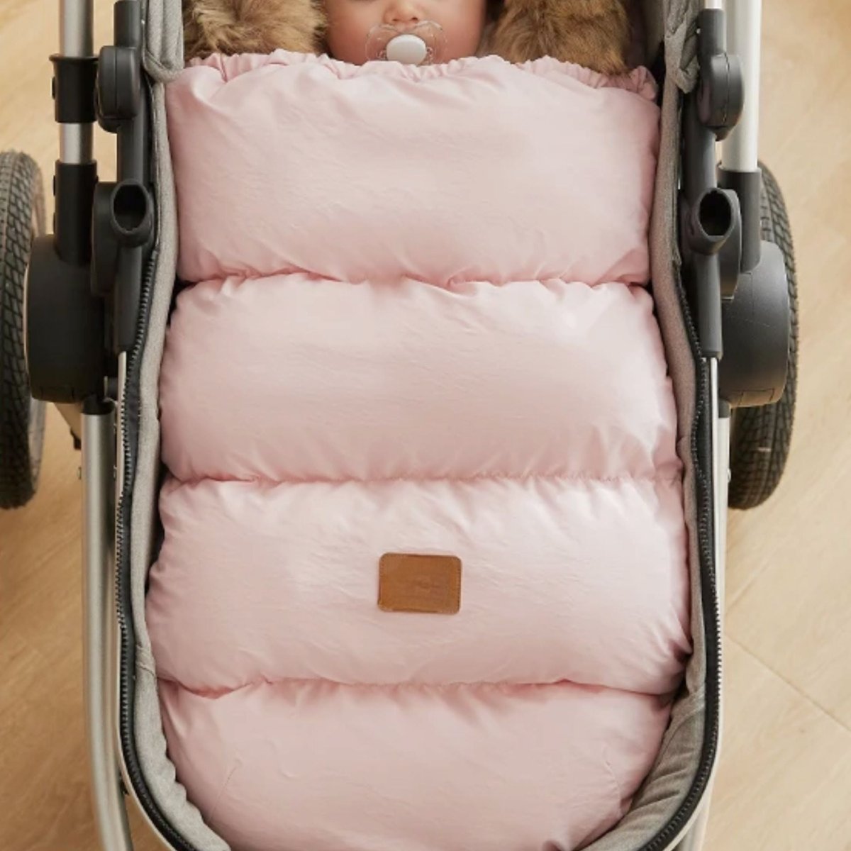 chanceliere bebe rose pale dans poussette, bébé emmitouflé confortablement, capuche fausse fourrure