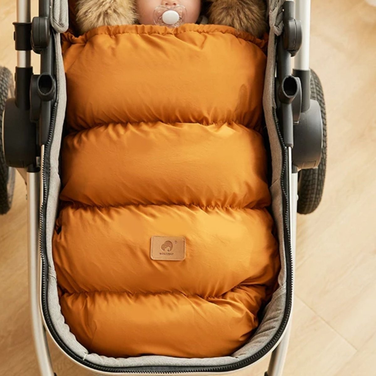 chanceliere bebe marron matelassée vue de dessus, bébé endormi avec tétine, capuche remontée