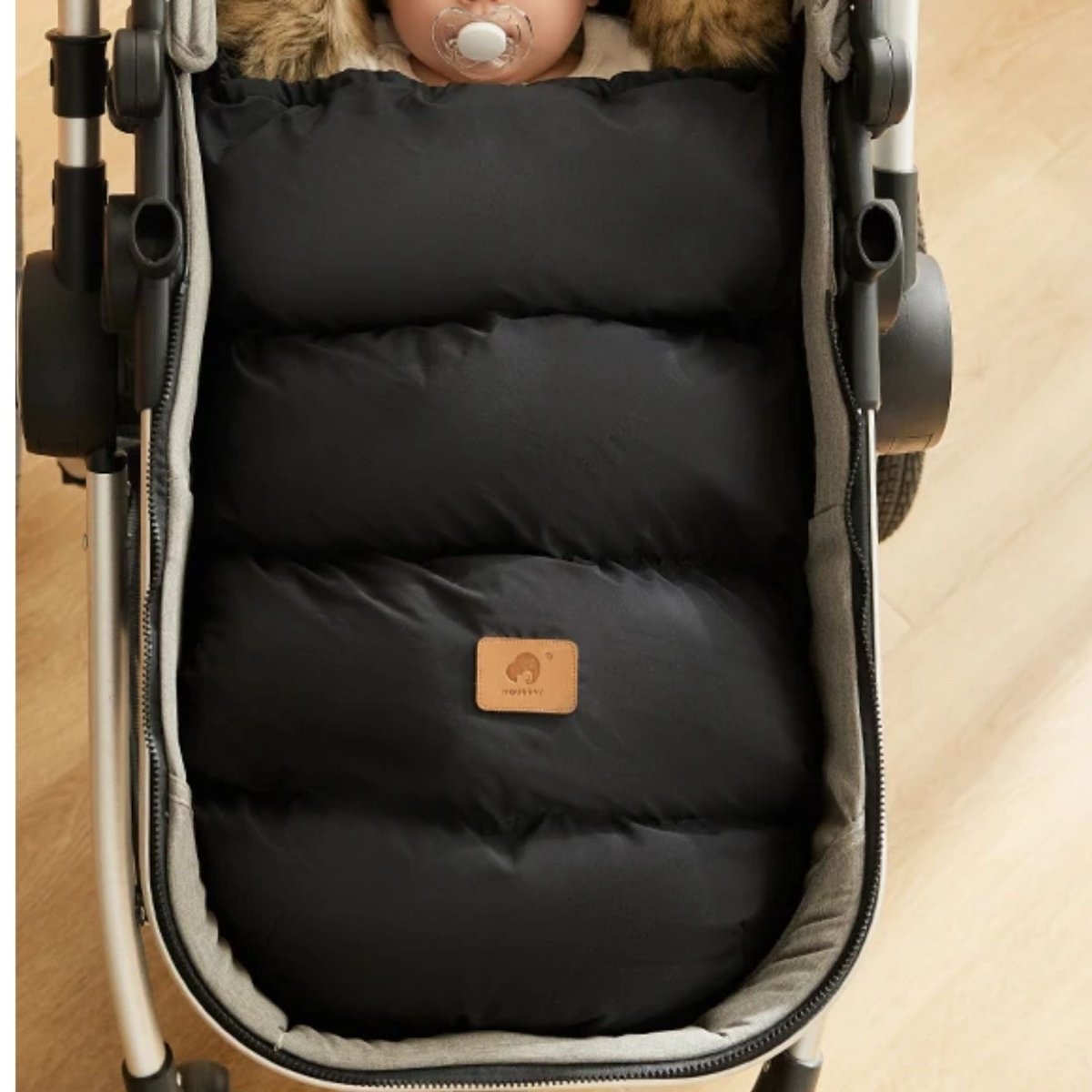 
chanceliere bebe noire fermée avec capuche fourrure, bébé dormant avec tétine, vue de dessus