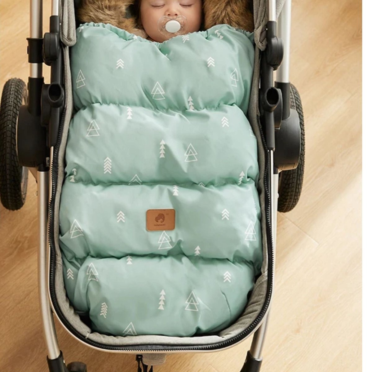 chanceliere bebe triangle vert noir marron vue frontale, bébé endormi à l’intérieur