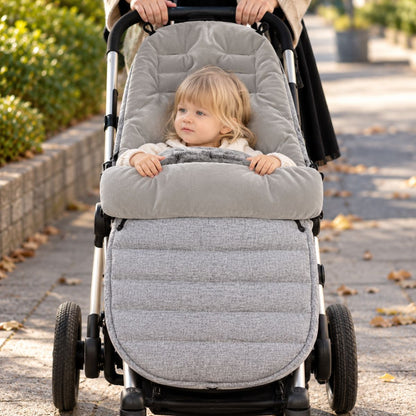 Chancelière évolutive gris clair vue de face avec bébé installé sur la poussette