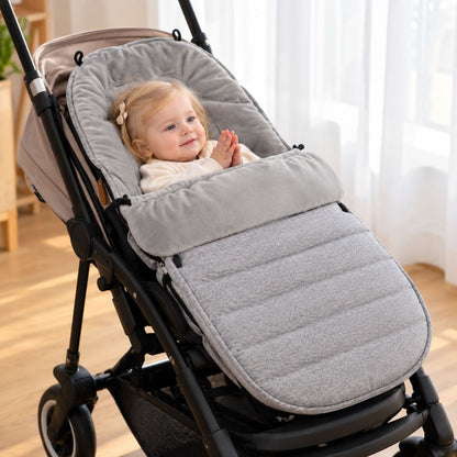 Chancelière évolutive gris clair avec partie avant matelassée et bébé installé