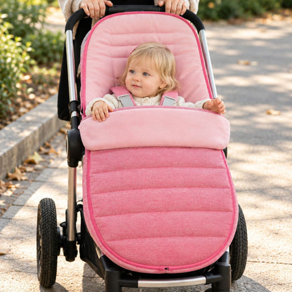 Chancelière évolutive rose vue de face avec bébé installé sur la poussette