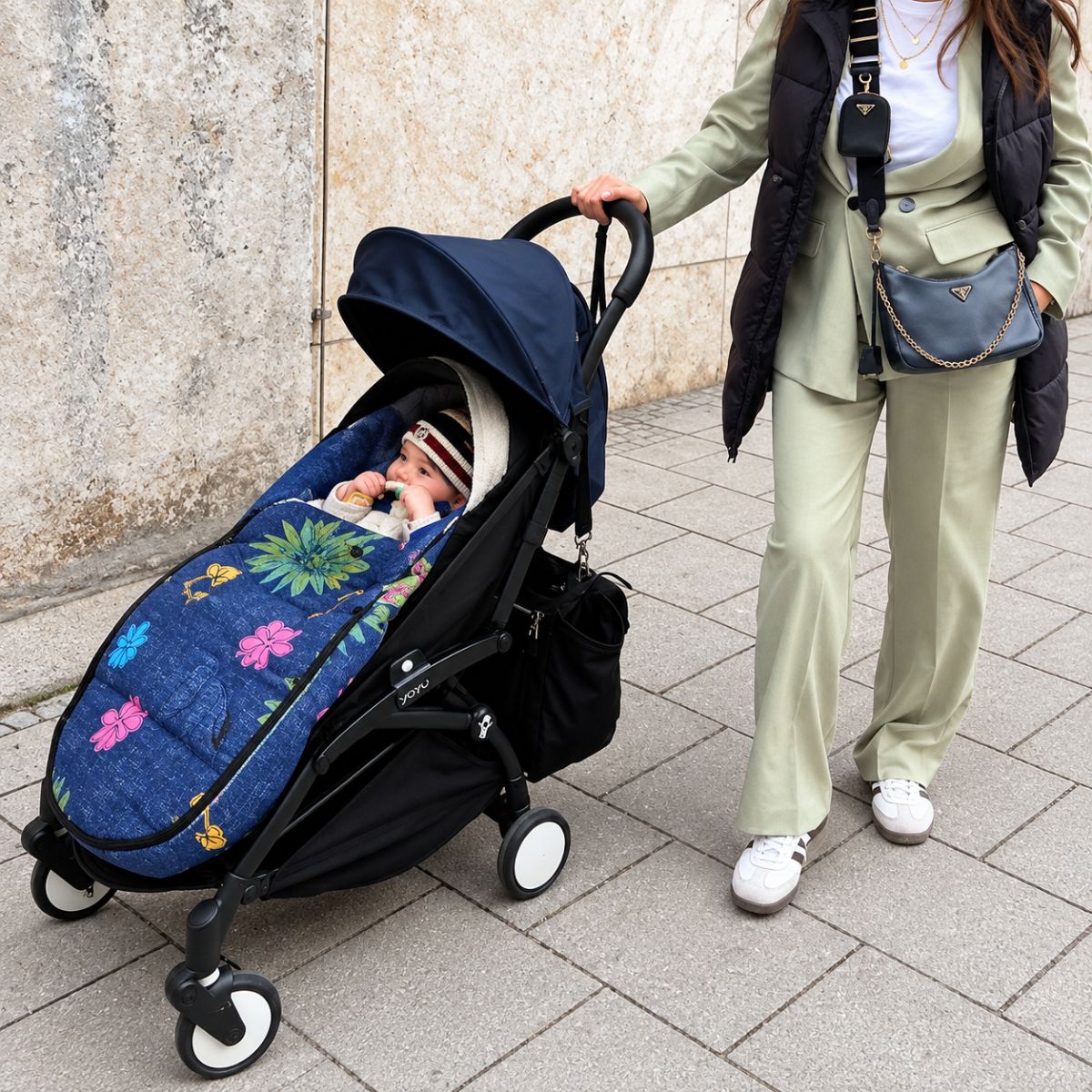 Chanceliere impermeable poussette bleu marine fleurie avec bébé installé lors d’une sortie en ville
