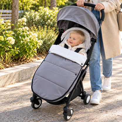 Chanceliere impermeable poussette gris avec bébé installé pendant une balade au parc