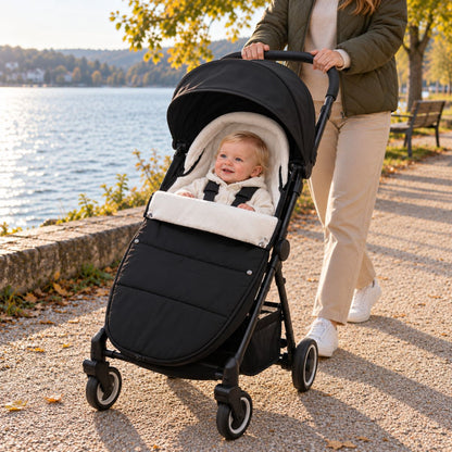 Chanceliere impermeable poussette noire avec bébé en balade près d’un lac
