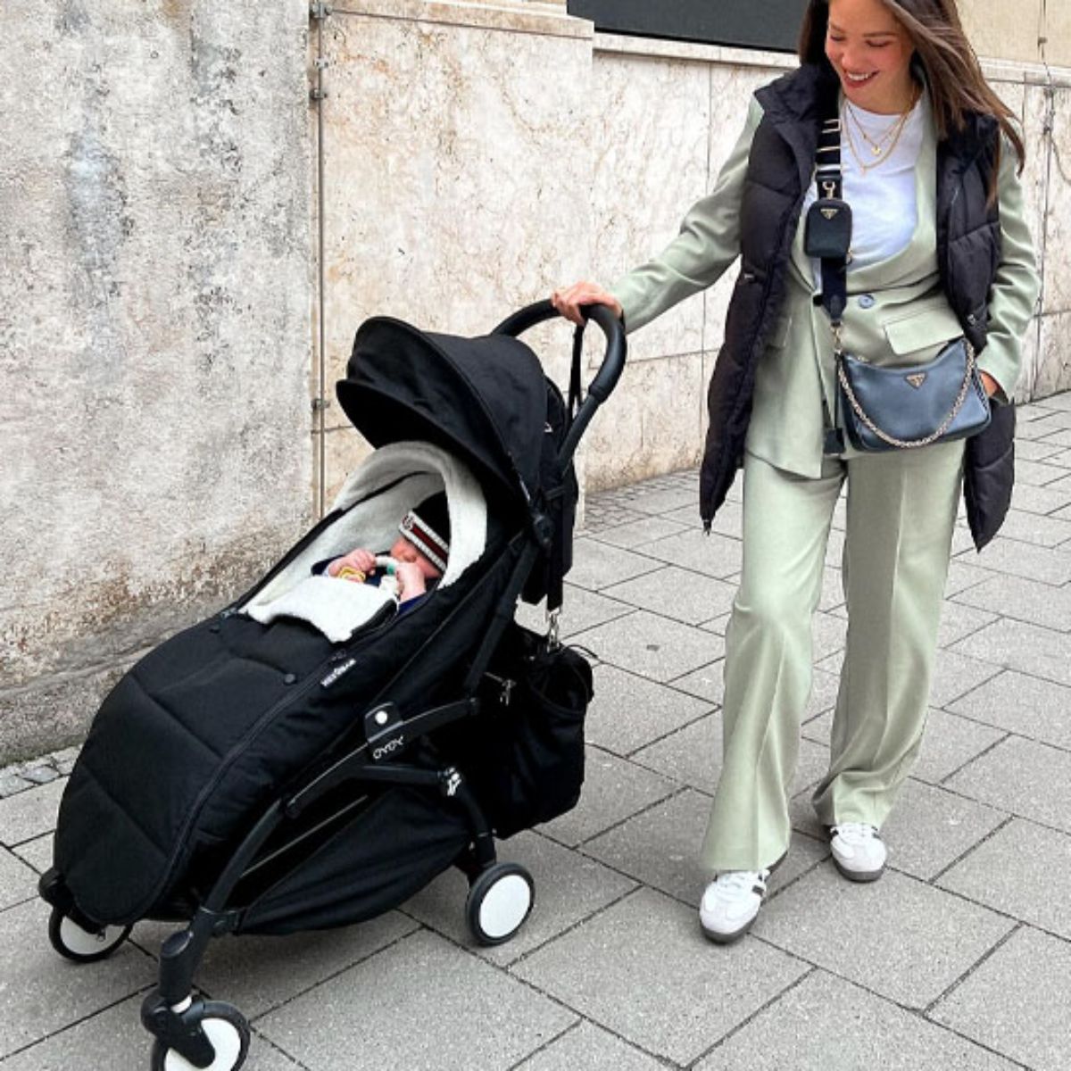 Chanceliere impermeable poussette noire avec bébé installé lors d’une sortie en ville