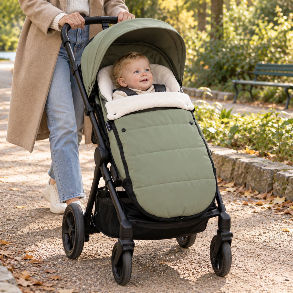 Chanceliere impermeable poussette olive avec bébé en balade sur un chemin extérieur