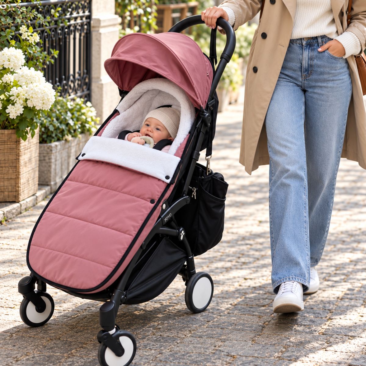Chanceliere impermeable poussette rose avec bébé pendant une balade extérieure