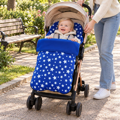 Chancelière polaire bleu roi à étoiles installée sur une poussette avec bébé au parc