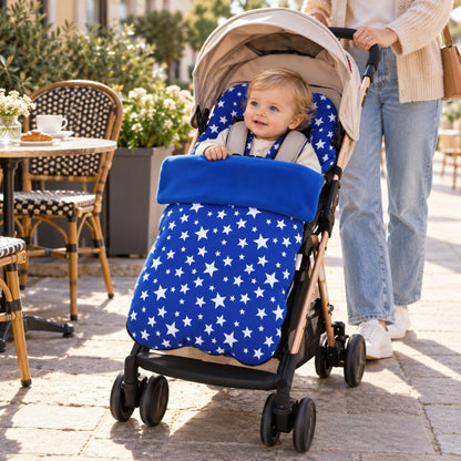 Chancelière polaire bleu roi à étoiles sur poussette avec bébé près d’une terrasse