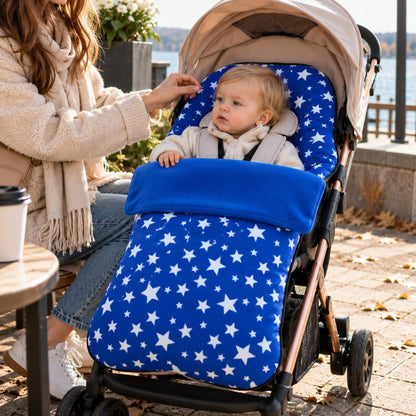 Chancelière polaire bleu roi à étoiles installée sur une poussette avec bébé au bord du lac