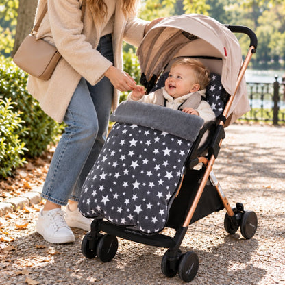 Chancelière polaire grise à étoiles sur poussette avec bébé lors d’une sortie au parc