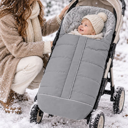 Chancelière poussette gris clair avec doublure polaire grise, bébé installé avec sa maman pendant une promenade dans la neige