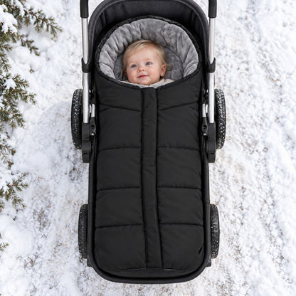 Chancelière poussette noire avec doublure polaire grise, vue de dessus avec bébé dans la neige
