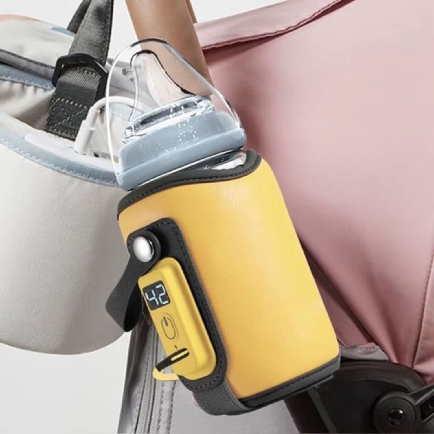 Chauffe biberon nomade électrique fixé sur une poussette, pratique pour maintenir la température du lait en déplacement – MamanPépite.

