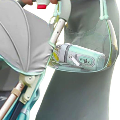 chauffe biberon vert menthe visible dans un sac accroché à une poussette en déplacement
