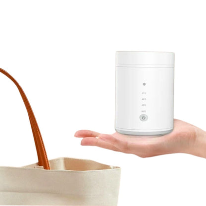 Chauffe biberon portable tenu à la main à côté d’un sac