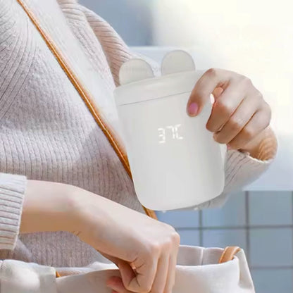 chauffe biberon usb blanc sorti d’un sac à main, prêt à l’utilisation en déplacement