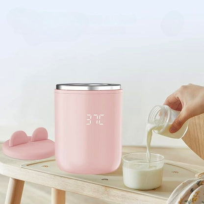 chauffe biberon usb rose utilisé avec du lait, posé sur une table en bois clair