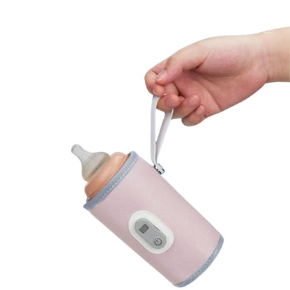 chauffe biberon USB rose tenu par une main, design nomade compact