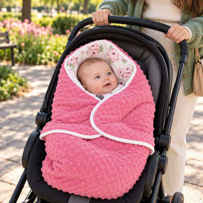 Couverture nomade bébé rose floral avec pans croisés, bordure blanche et capuche à imprimé de fleurs roses et feuilles vertes