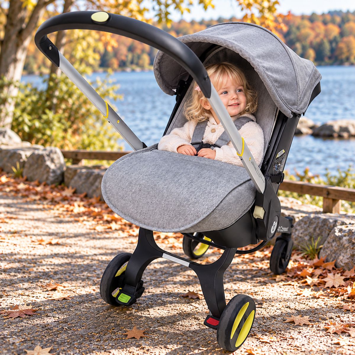 Couvre pied poussette gris installé devant les jambes de bébé lors d’une promenade au bord du lac