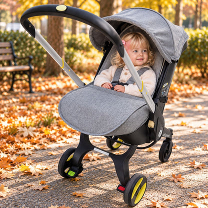 Couvre jambes poussette gris avec bébé installé dans la poussette pendant une sortie au parc