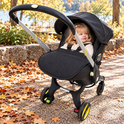 Couvre jambe poussette noir installé devant les jambes de bébé dans un parc en automne