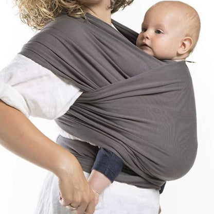 Echarpe de portage nouée sur le devant, bébé blotti contre la poitrine du parent