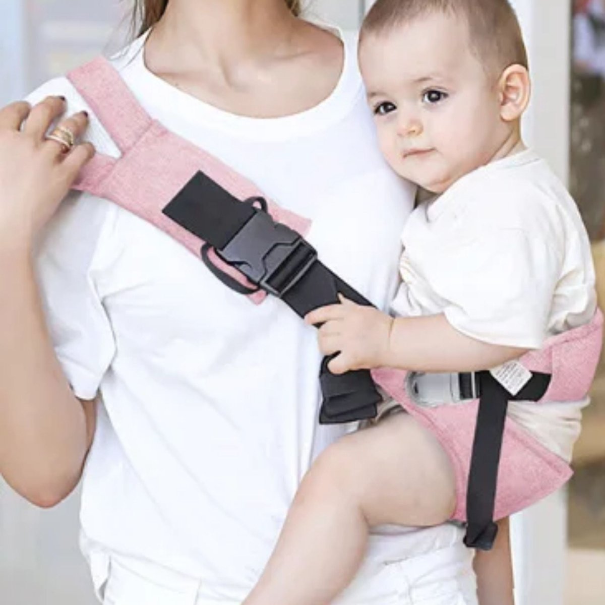 Maman portant bébé avec echarpe de portage rose et boucle large de maintien