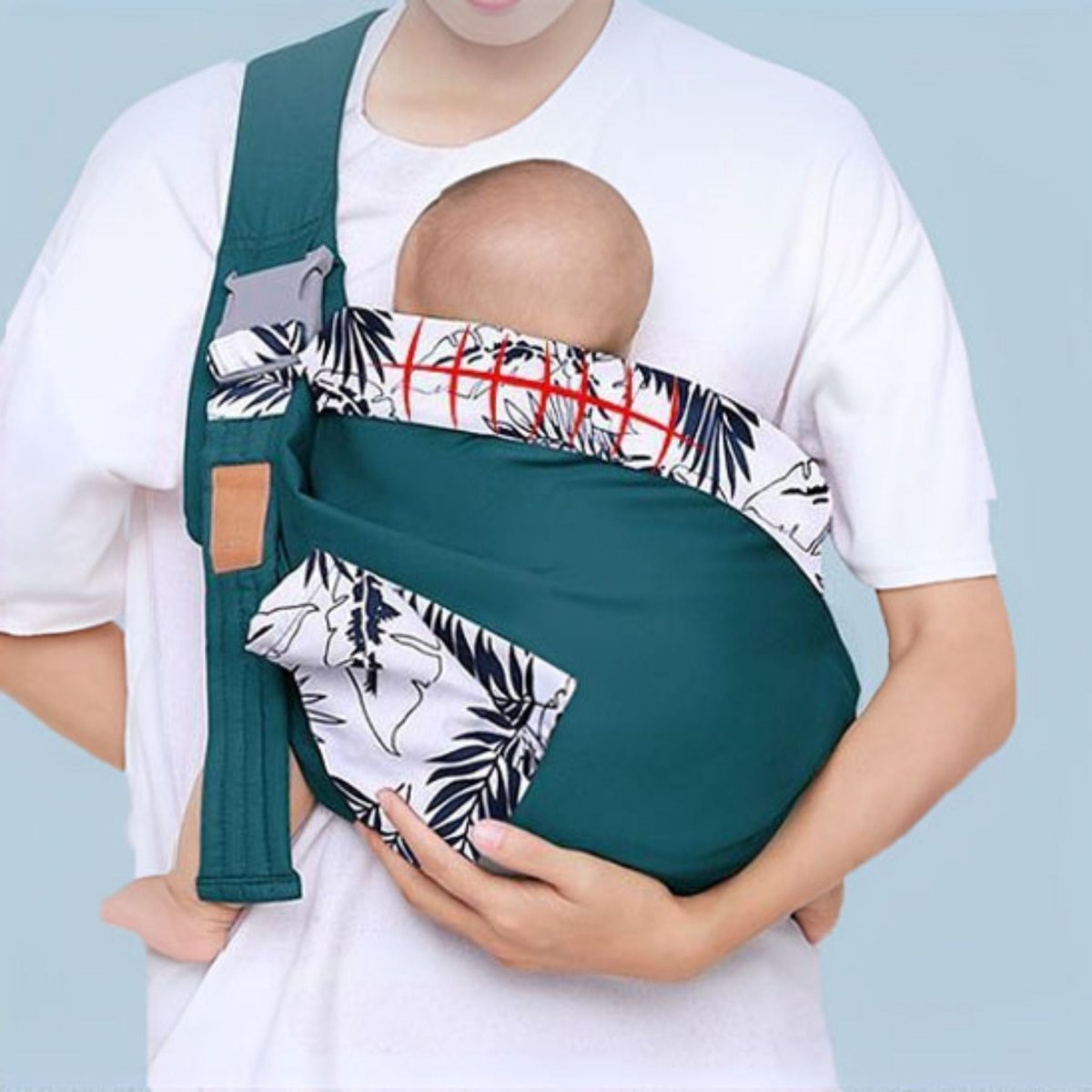 echarpe de portage vert jungle avec bébé installé en position poitrine, détail imprimé noir et blanc visible sur le bord supérieur