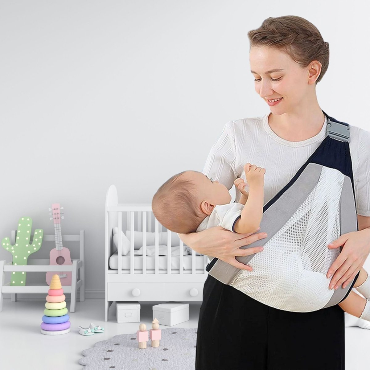 Sourire maternel en chambre bébé avec écharpe de portage grise et maille filet