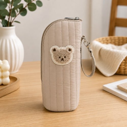 Étui matelassé pour biberon beige avec écusson ourson, vue de face et sangle amovible
