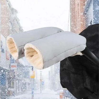 Gants de poussette gris clair avec doublure blanche épaisse, fixés au guidon sur fond de rue enneigée