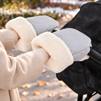 Gants de poussette gris clair avec doublure blanche douce, portés au guidon pendant une promenade hivernale