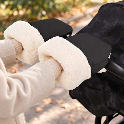 Gants de poussette noirs à boutons-pression avec doublure douce blanche, portés au guidon pendant une promenade