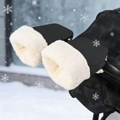Gants de poussette noirs avec doublure blanche d'aspect polaire, installés sur un guidon dans un décor enneigé