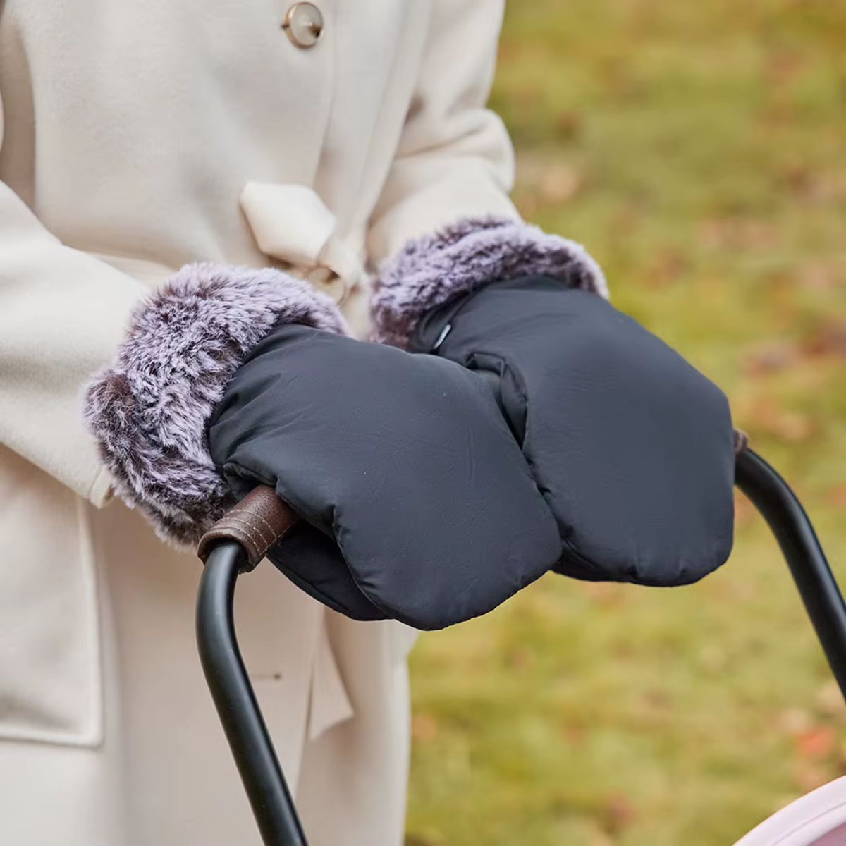 Gants de poussette effet fourrure noirs installés sur un guidon courbé